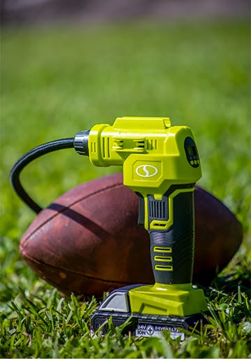 Auto Joe 24-volt cordless portable air compressor being used to inflate a football.